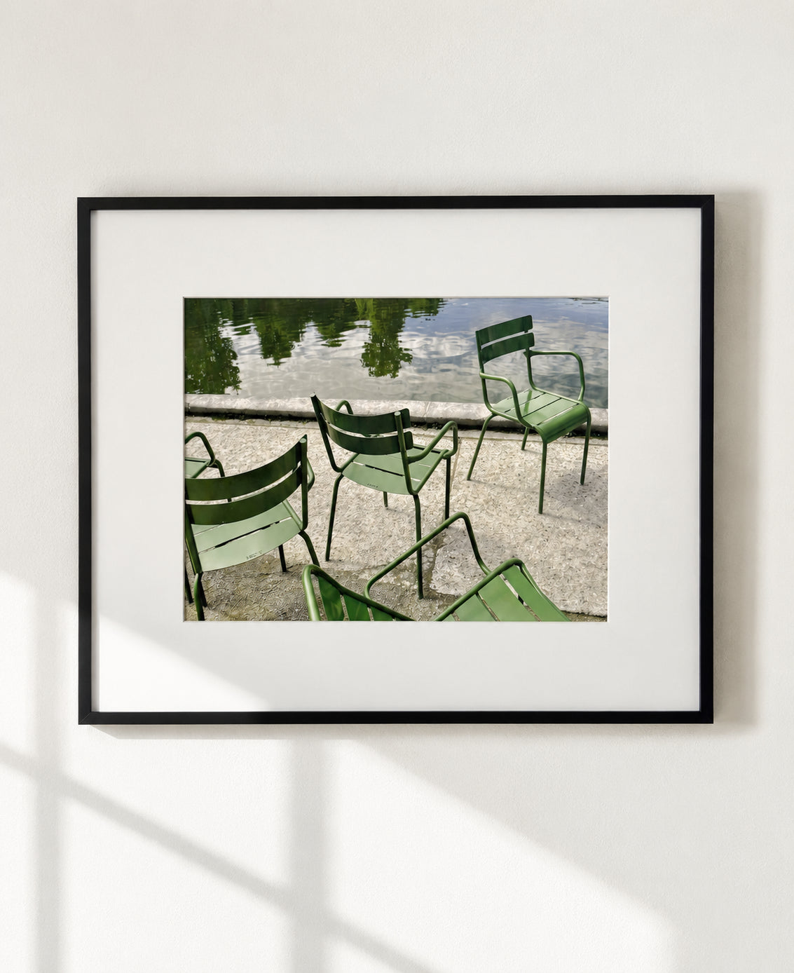 Photograph of green metal chairs beside the Grand Bassin in the Luxembourg Gardens, matted in a black frame